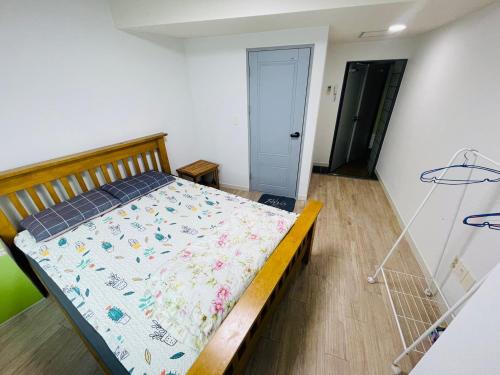 a bedroom with a bed with a blanket on it at Beach Stay Guesthouse in Busan