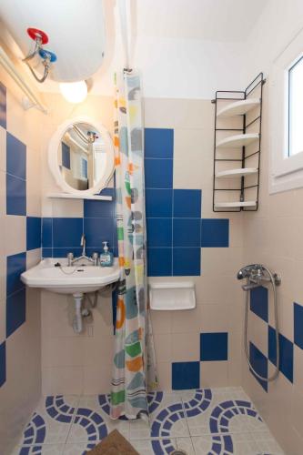 a blue and white bathroom with a sink and a shower at PAROS APARTMENT MELAS b1 in Parikia