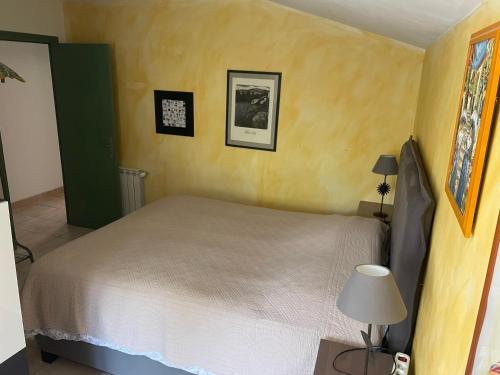 une chambre avec un lit et une table avec une lampe dans l'établissement La maison de Beaumes, à Beaumes-de-Venise