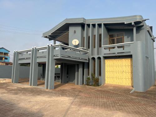 a building with a yellow door and a garage at Ghanavilla3 in Tantra Hill