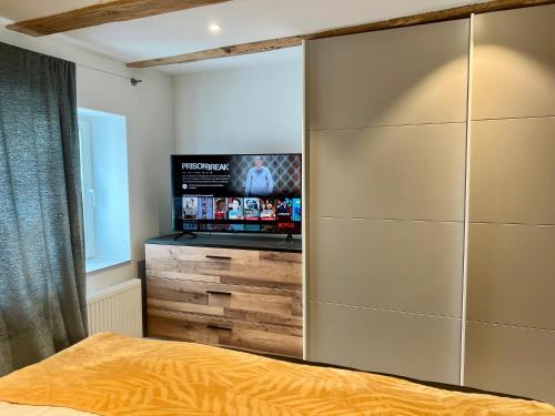 a bedroom with a large wardrobe with a flat screen tv at Wiesenau Apartments by Restaurant WIESENAU in Prerow
