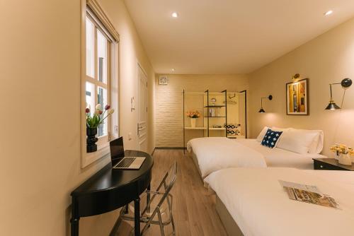 une chambre d'hôtel avec deux lits et un bureau dans l'établissement Serviced Apartments in Heart of Old quarter by SSens Homes, à Hanoï