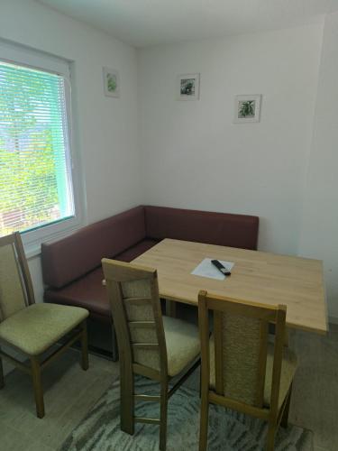 a table and chairs and a couch in a room at Apartments Amina Sarajevo in Sarajevo