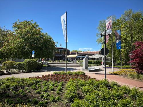 a park with flags and flowers in front of a building at Ferienwohnung HeilbadOase in Erwitte