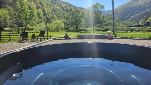 a pool of water with a person sitting on a bench at Котеджі Карпати Fest in Mizhhirʼʼya