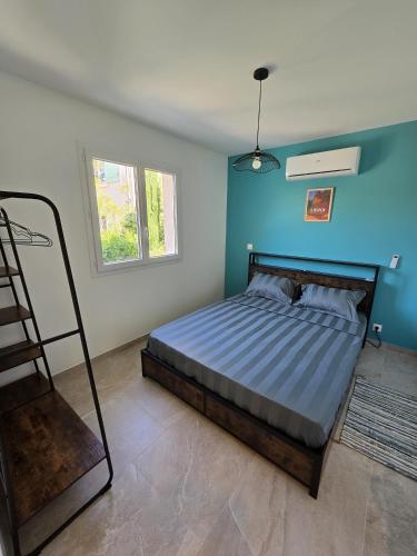 a bedroom with a bed with a blue wall at Cocoon Luberon in Lauris