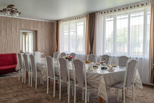 a dining room with a long table and chairs at Sunny Valley Guest House Karakol in Karakol