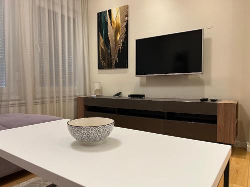 a living room with a tv and a bowl on a table at Sanja & Mirza Apartments - Old Town Sarajevo in Sarajevo