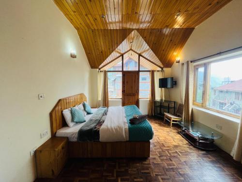 una camera da letto con un letto grande con soffitto in legno di Could 9 cottage a Manāli