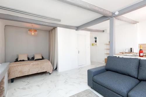 une chambre avec un lit et un canapé bleu dans l'établissement Renoveted studio - Central - AC, à Cannes
