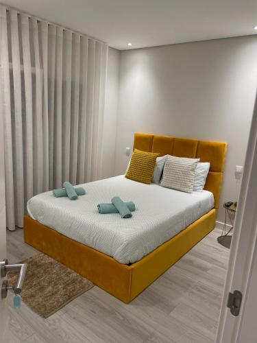 a bedroom with a bed with two pillows on it at homeSilvaSanches in Quinta do Conde