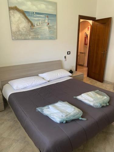 a bed with two pillows on it in a bedroom at Appartamento a Marina di San Nicola Roma in Palo