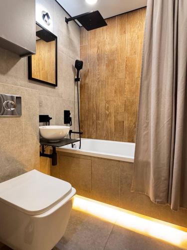 a bathroom with a toilet and a sink and a tub at 2 комнатная в историческом центре Наурызбай батыра 41 in Almaty