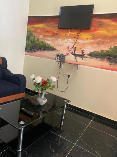 a living room with a table and a painting at Résidence Yavanie in Kribi