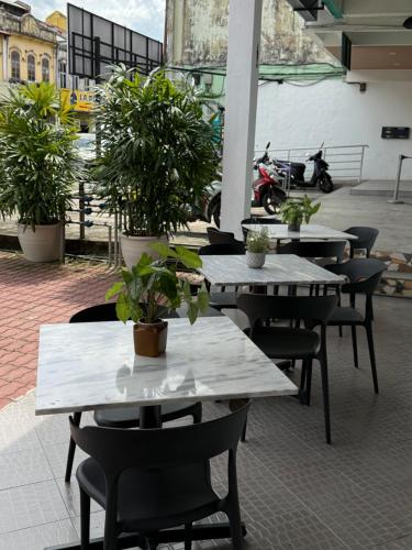 彭亨Winn's Hotel Bentong的一组桌椅,上面有盆栽植物