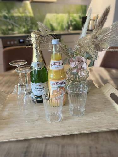 a wooden table with two bottles and glasses on it at Ferienwohnung Seestraße in Plau am See