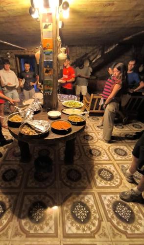 a group of people standing around a table with food on it at Dana bedouin Sky in Dana