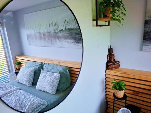 a mirror in a room with a bed with pillows at Zenovna - Reset v Beskydech in Frýdlant nad Ostravicí