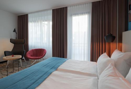a hotel room with a bed and a red chair at Turm Hotel in Frankfurt/Main