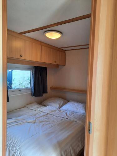 a bed in a small room with a window at Groene Oase in Epe