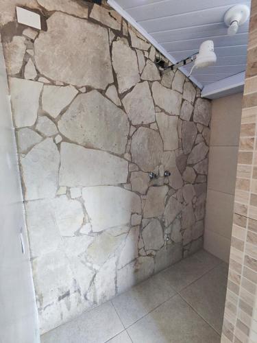 a stone wall in a shower in a bathroom at Pousada Acayaca in Diamantina