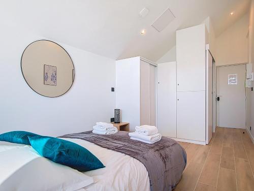 Un dormitorio con una cama con un espejo en la pared. en Suite Fashion Week - Appartement central, en Argenteuil