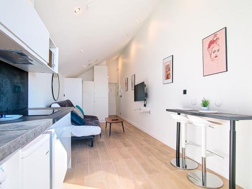 Il comprend une cuisine et un salon aux murs blancs. dans l'établissement Suite Fashion Week - Appartement central, à Argenteuil