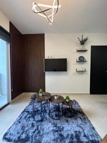a living room with two tables and a tv at Departamento Orion 3 rooms planta baja en Cancun by EITA in Cancún