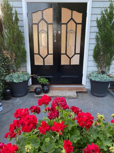 a black door with red flowers in front of a house at Studio 59 Newport sleeps1 in Newport