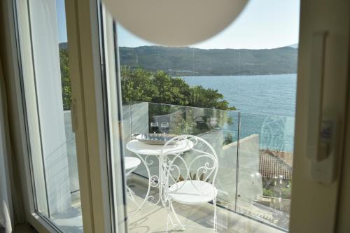 a balcony with a table and chairs and a view of the water at Samos Endless Blue in Samos