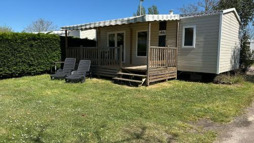a tiny house with two chairs and a porch at Mobilhome Ile d'Oléron - 6 places - Camping 5 étoiles in Saint-Georges-dʼOléron