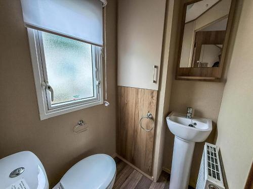 ein Badezimmer mit Toilette und Waschbecken und einem Fenster in der Unterkunft Lovely 6 Berth Caravan At St Osyth Beach Holiday Park Ref 28059Fv in Clacton-on-Sea
