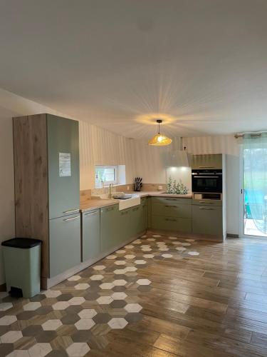 Il comprend une grande cuisine avec des placards blancs et du parquet. dans l'établissement Gîte la route des vins de Mahé, à Chouzé-sur-Loire