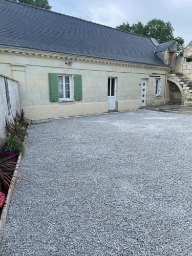 un bâtiment avec une allée en gravier en face de celui-ci dans l'établissement Gîte la route des vins de Mahé, à Chouzé-sur-Loire