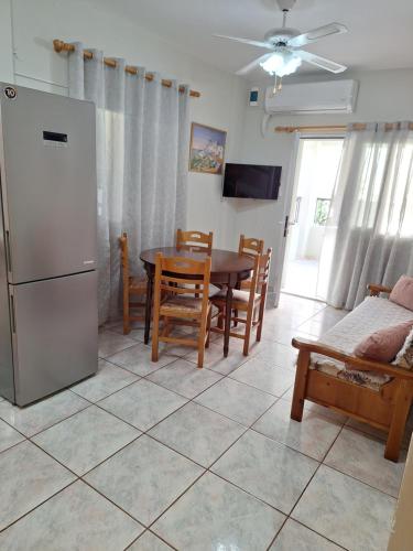 a kitchen and dining room with a table and a refrigerator at 85 sqm Apartments New Panorama ELECTRIC CAR ΦΩΡΤΗΣΗΣ STATION in Paralion astros