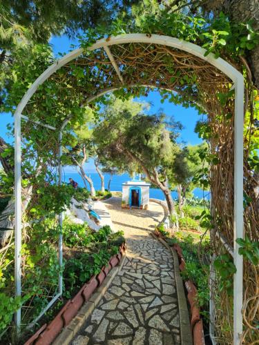 an archway leading to a garden with trees at 85 sqm Apartments New Panorama ELECTRIC CAR ΦΩΡΤΗΣΗΣ STATION in Paralion astros