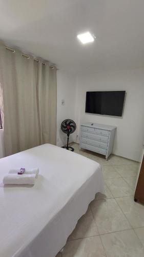 a bedroom with a white bed and a flat screen tv at Ap Família Shopping Riomar e Praia in Aracaju