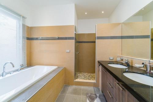a bathroom with two sinks and a bath tub at Luxury Pool Villa 604 4BR 10 Persons BBQ in Nong Prue