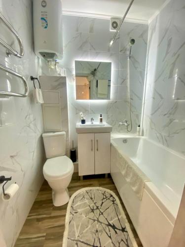 un bagno con un water, una vasca e un lavandino di Стильные апартаменты со свежим ремонтом на ЖД вокзале a Qostanay