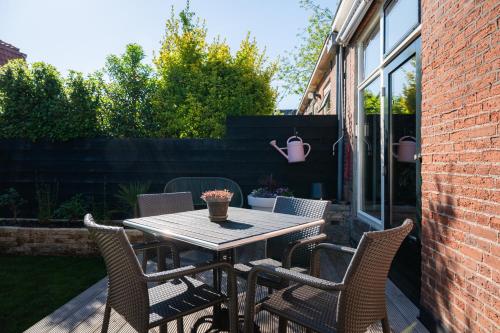 a wooden table and chairs on a patio at Vakantiehuisje De Barones in Middelburg