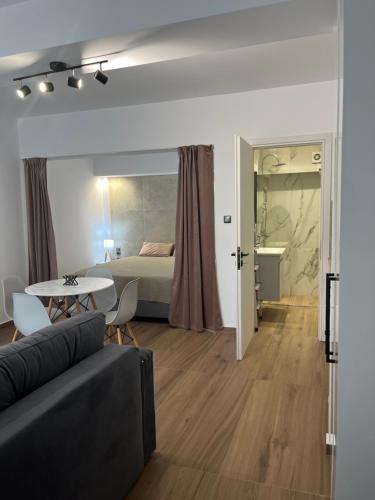 ein Wohnzimmer mit einer Couch, einem Bett und einem Tisch in der Unterkunft Mannou Studio in Paralia Vrachou