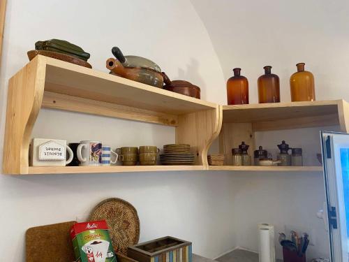 a room with wooden shelves with dishes and bottles at artgohomes in Hammamet
