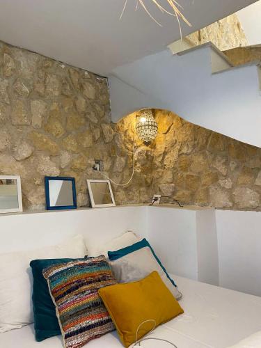 a room with a stone wall and a couch with pillows at artgohomes in Hammamet