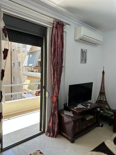 a room with a sliding glass door with a window at Gledis Apartment in Berat