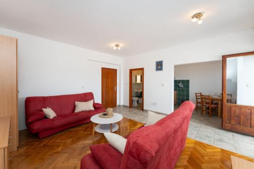 a living room with two red couches and a table at Spacious Apartments by the Sea in Srima, Vodice in Srima