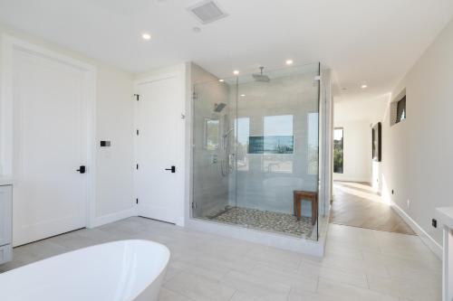 Un baño blanco con ducha y bañera. en Luxury Pool Haven Scenic Views and Summer Fireworks, en San Diego