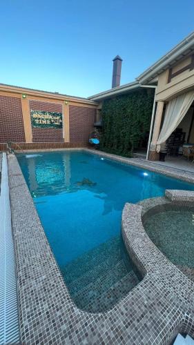 a swimming pool in front of a house at Dacha Time in Samarkand