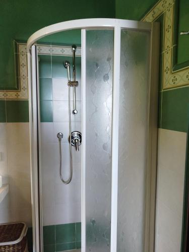 una ducha con puerta de cristal en un baño en Sea View Apartment with Terrace & Free Parking, en San Lorenzo al Mare