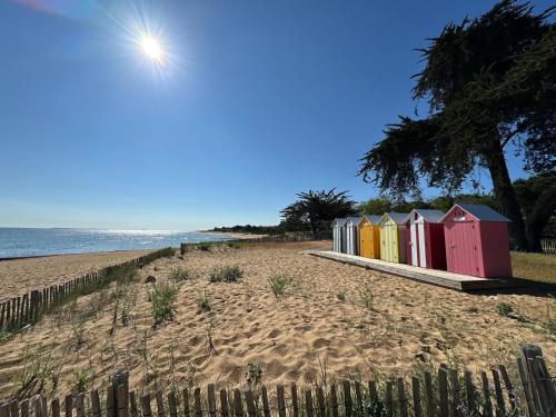 a row of colorful beach huts on a beach at Mobilhome Ile d'Oléron - 6 places - Camping 5 étoiles in Saint-Georges-dʼOléron