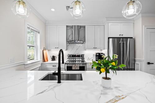 a white kitchen with a sink and a refrigerator at Forest Hill condos -Boston in Boston